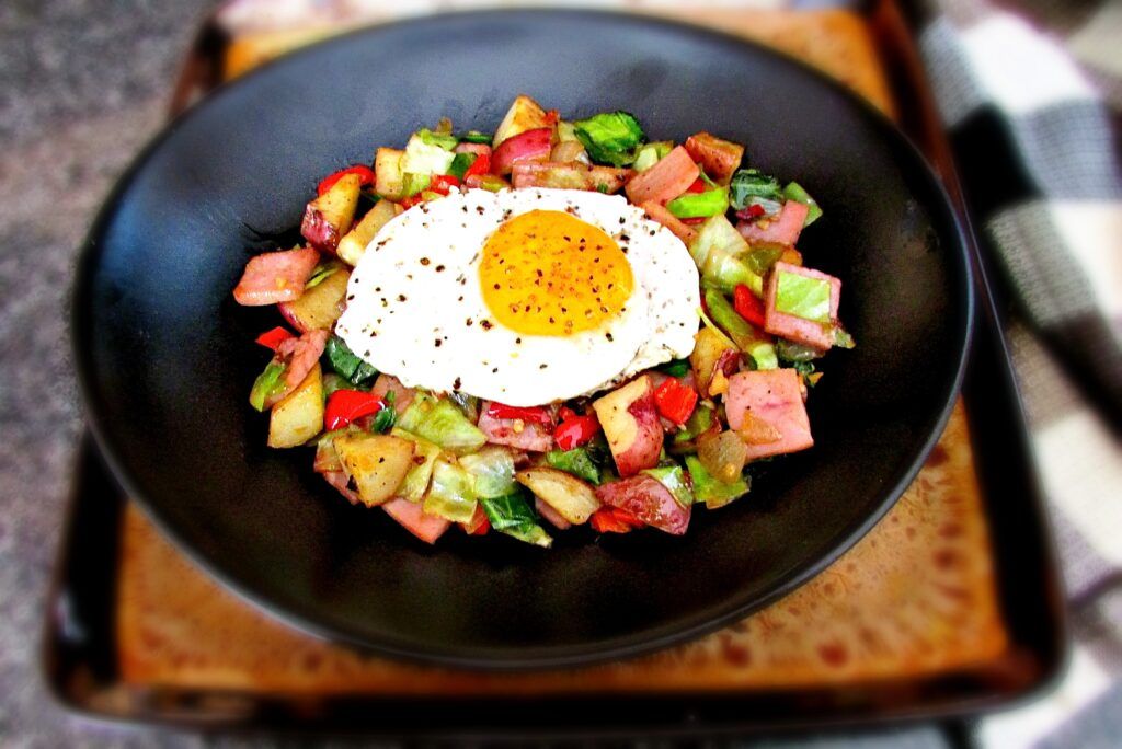 Spiral Ham and Cabbage Hash with Sunshine Egg in Black Bowl